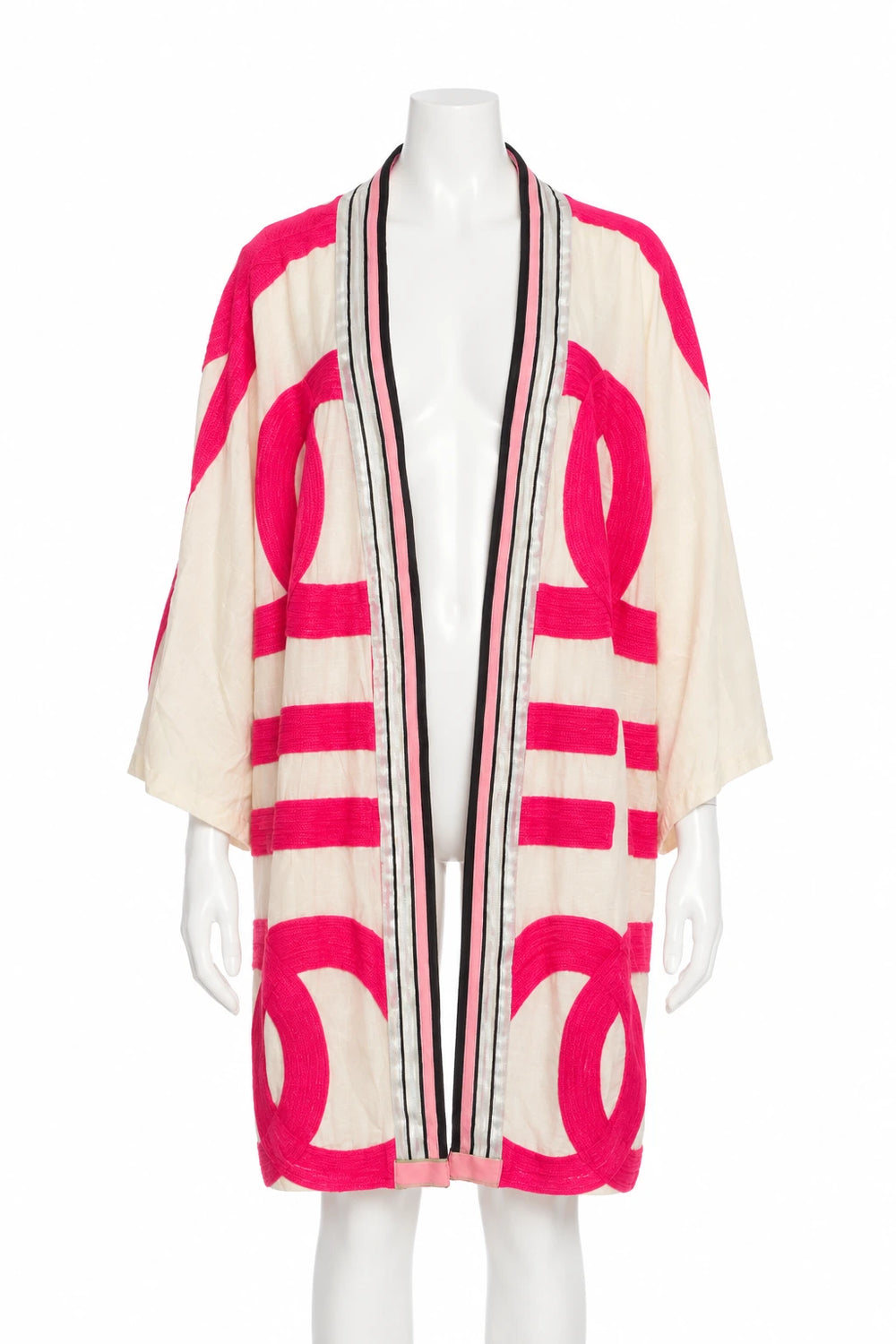 Cremefarbener Kimono mit pinken strukturierten Symbolen und gestreifter Blende auf weißer Schaufensterpuppe · Vorderansicht